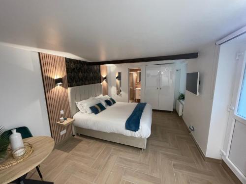 ein Schlafzimmer mit einem großen Bett und einem Tisch in der Unterkunft Eiffel Tour Cosy Jade in Paris