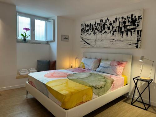 a bedroom with a large bed with a painting on the wall at Residenza d'Artista al Duomo1 in Salerno
