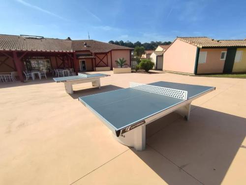 - deux tables de ping-pong assises sur une terrasse dans l'établissement Maison charmante à Soustons avec piscine et jardin, à Soustons
