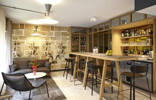 um bar com cadeiras e uma mesa num quarto em Mercure Paris Bastille Saint Antoine em Paris