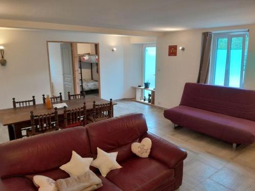 un salon avec un canapé et une salle à manger dans l'établissement Gîte Les Petits Bonhommes, à Gerde