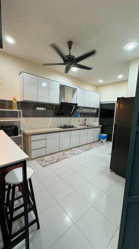 a kitchen with a ceiling fan and a white tile floor at Homestay Bagan Serai in Bagan Serai