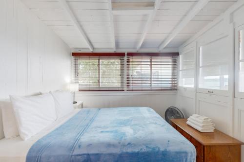 a white bedroom with a large bed and a window at Nirvana at Keuka in Keuka Park