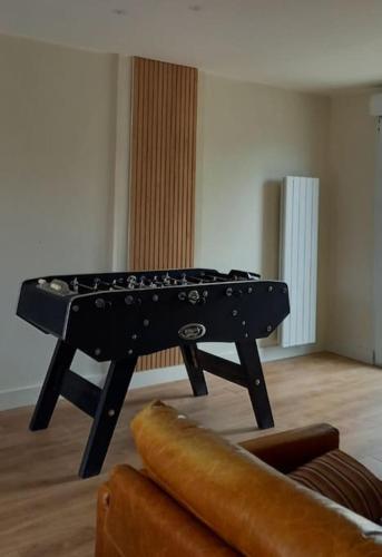 a black piano sitting in a living room at Gîte du Vieux Puits in Merlimont
