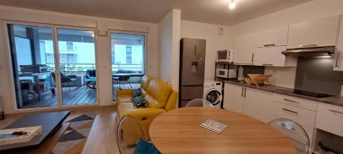 - une cuisine avec une table et un canapé dans une chambre dans l'établissement Spacious apartment near the sea, à La Baule