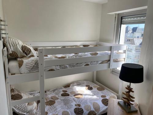 deux lits superposés dans une chambre avec fenêtre dans l'établissement Appartement face mer Pornichet, à Pornichet