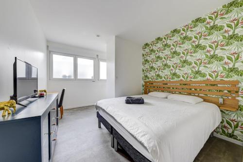 une chambre avec un lit et un bureau avec une télévision dans l'établissement Lovely studio for 2 near the Seine, à Paris