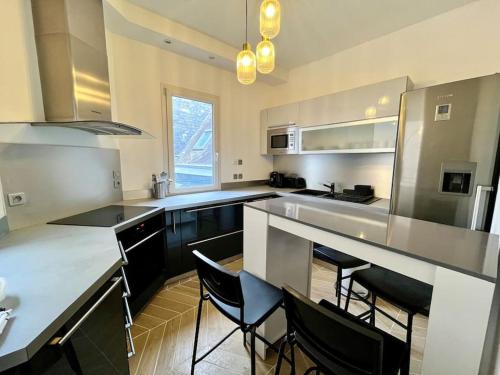 une cuisine avec un grand comptoir et des chaises. dans l'établissement Emeraude, à Rouen