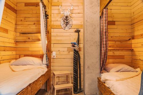 2 aparte bedden in een kamer met houten wanden bij Gites La Boletiere in Saint-Étienne-du-Valdonnez