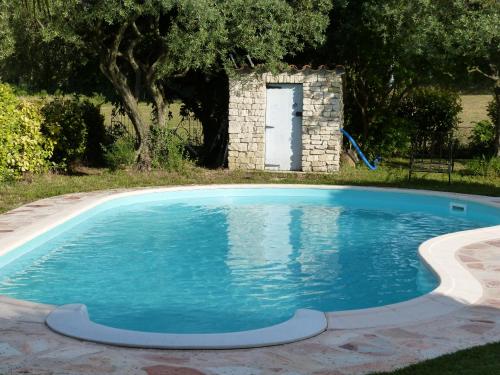 une piscine dans une cour avec une porte blanche dans l'établissement Gîte de charme en Provence, à Pernes-les-Fontaines