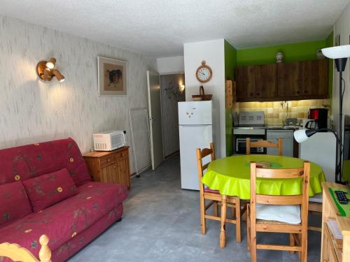 un salon avec un canapé et une table et une cuisine dans l'établissement Appartement à Autrans, 39m², 6 pers, proche pistes et village, balcon est, parking privé - FR-1-737-42, à Autrans