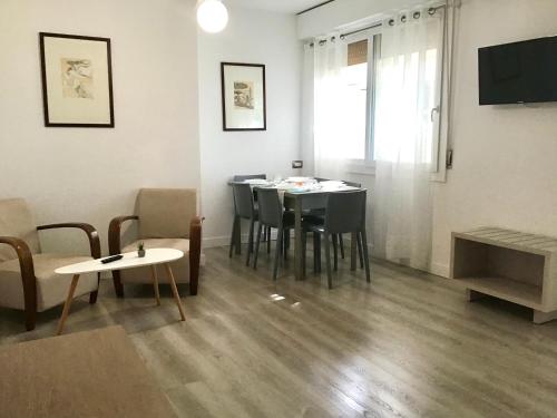 a living room with a dining room table and chairs at La Coccinella Residence in San Vincenzo
