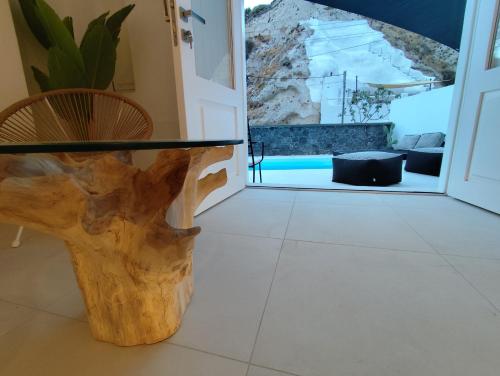 a glass table on a tree stump in a room at The Magic Luxury Cave Suites in Vóthon