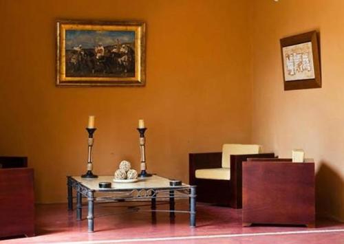 a living room with a table and a chair at Hotel Hacienda Mérida VIP in Mérida