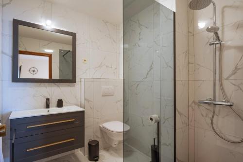 a bathroom with a shower and a toilet and a sink at Apartments Linda in Prizba