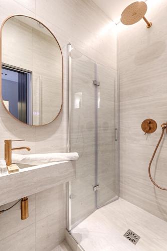 une salle de bain avec une douche, un lavabo et un miroir dans l'établissement Luxury and Design Studio Invalides, à Paris