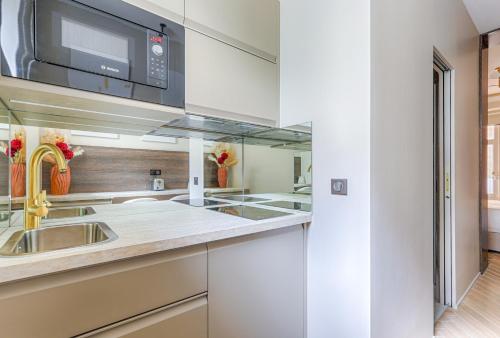 une cuisine avec un évier et un micro-ondes dans l'établissement Luxury and Design Studio Invalides, à Paris