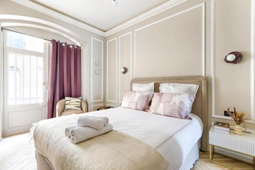 une chambre avec un grand lit blanc avec des rideaux violets dans l'établissement Luxury and Design Studio Invalides, à Paris