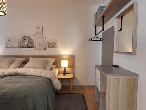 a bedroom with a bed and a desk with a lamp at Provinzial Ferienwohnung Walter in Wadgassen