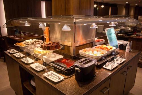a buffet line in a hotel room with food at Hotel Deville Curitiba in Curitiba
