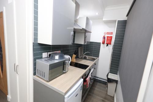a small kitchen with a sink and a microwave at VR Apartments in Glasgow
