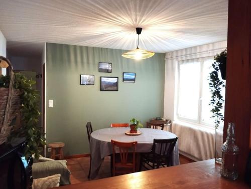 カンパンにあるAppartement au cœur du village de campanのテーブルと窓のあるダイニングルーム