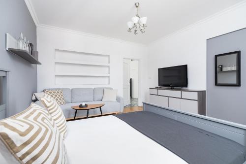a white bedroom with a bed and a couch at Two Bedroom Apartment- Brzozowa - Kazimierz in Kraków
