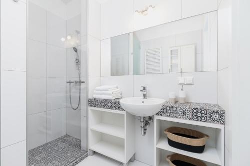 a white bathroom with a sink and a shower at Two Bedroom Apartment- Brzozowa - Kazimierz in Kraków