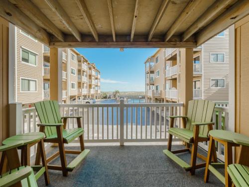 a balcony with chairs and a view of the water at Sand Pebbles #A3 - Pelican Perch in Carolina Beach