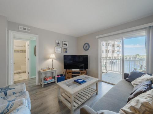 a living room with a couch and a flat screen tv at Sand Pebbles #A3 - Pelican Perch in Carolina Beach