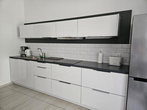 a white kitchen with white cabinets and appliances at Apartamenty Wisełka in Wisełka