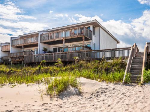 a house on the beach next to the sand at Queens Grant 211C in Surf City