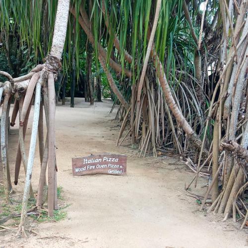 a sign in front of a bunch of palm trees at Cinnabar Resort in Tangalle