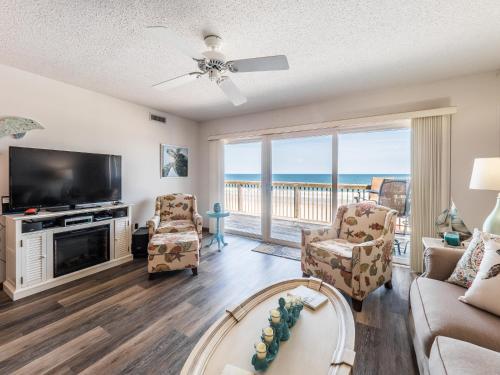 a living room with a television and a couch and chairs at Queens Grant 211C in Surf City