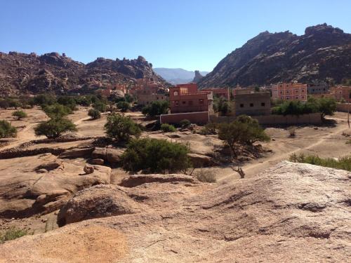 a village in the desert with mountains in the background at Maison d'hôtes afoulki tafraout in Tafraoute