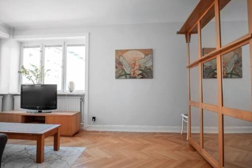 a white living room with a tv and a table at Apartment in Södermalm 1-4 people 47 sqm in Stockholm