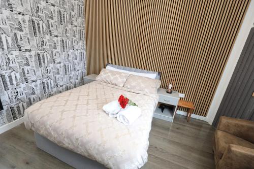 a bedroom with a bed with a flower on it at VR Apartments in Glasgow