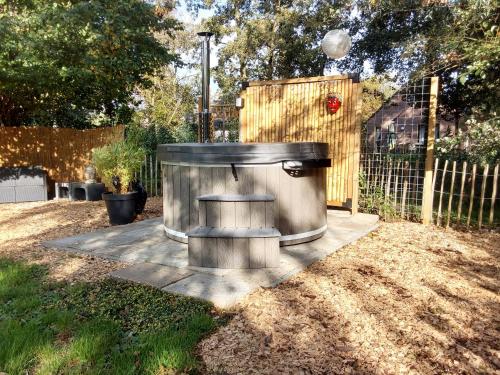 a metal trash can sitting in the middle of a yard at Rumah Senang Wellness met hottub en tuin in Ewijk
