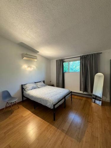 a bedroom with a bed and a window and a chair at Entire Home 3 bds 2 bats in Seattle