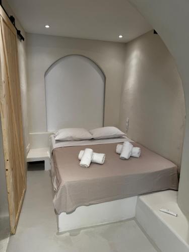 a bedroom with a bed with two towels on it at White Sand Cave Suite in Ios Chora