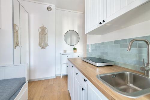 a kitchen with white cabinets and a sink at DR Apartments - Parkowa in Sopot