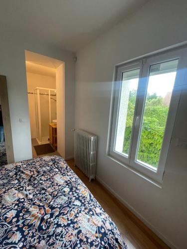 a bedroom with a bed and a window at Charmante maison de ville in Caen