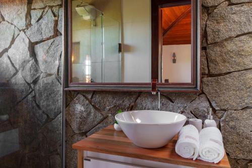 a bathroom with a sink and a mirror and towels at Bela Vista Ferradura in Búzios