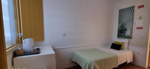 a small room with a bed and a window at Rosa dos Ventos in Zambujeira do Mar
