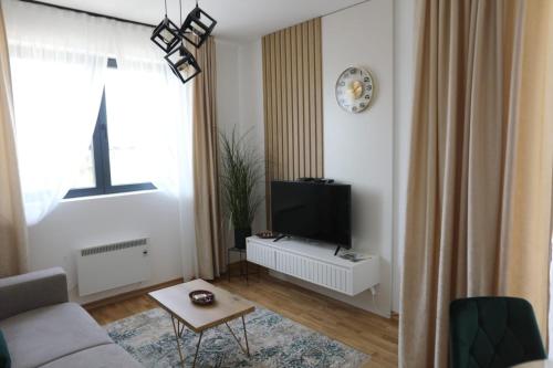 uma sala de estar com um sofá e uma televisão em Zlatiborske terase Spa&Wellness em Zlatibor