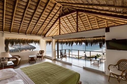 a bedroom with a bed and a view of the ocean at Casa en el Aire in Los Órganos