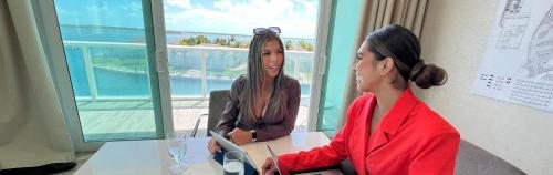 two women sitting at a table in a room at Resorts World Bimini in Alice Town