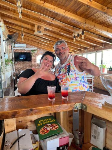 a man and a woman standing at a bar at Hotel Arsenal in Ksamil