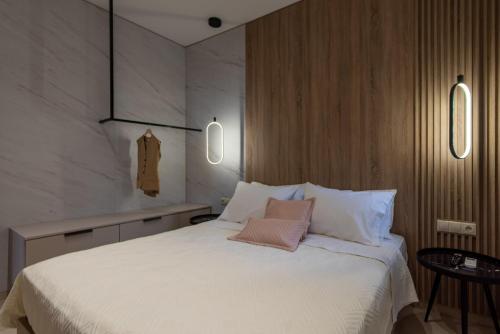 a bedroom with a large white bed with two pink pillows at Evelyn Villa Crete in Tsoútsouros