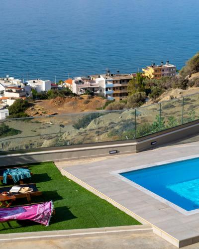 a villa with a swimming pool and a view of the ocean at Evelyn Villa Crete in Tsoútsouros